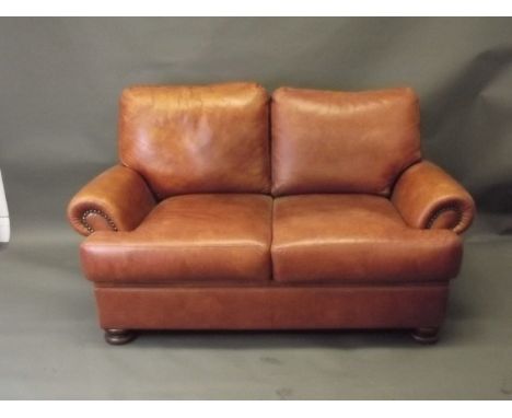 A John Lewis two seater sofa in tan leather, 57'' x 33'' x 35''