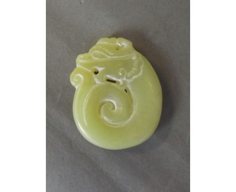 A Chinese jade pendant with carved dragon head decoration, 1¾'' long