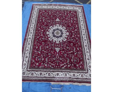A large Kashmiri shabaz design carpet with central cream medallion and border on a red field, 108'' x 150''
