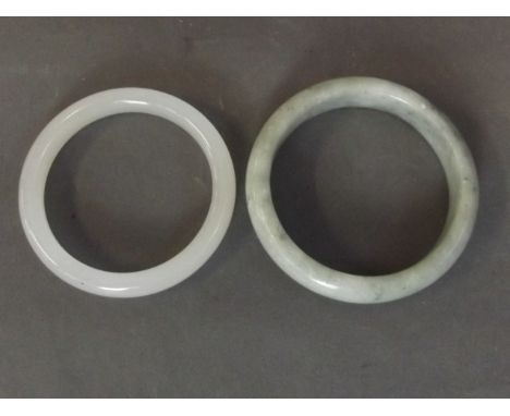 A Chinese white jade bangle, and another mottled green jade bangle, 3'' diameter