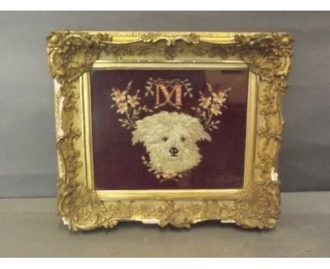 A framed woolwork pictures of a dog, initialed 'M' amongst flowers, in a good gilt frame, 9½'' x 7½''