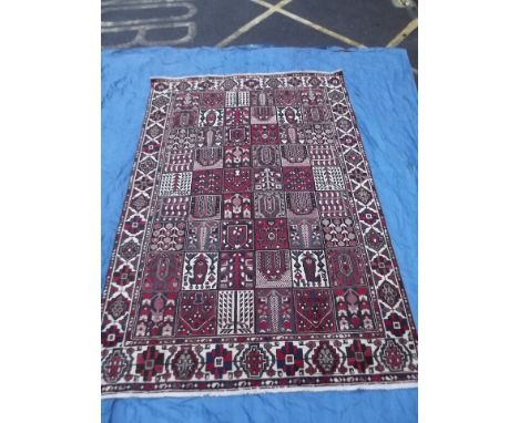 A Persian Bakhtiari wool carpet with panelled design on a red field, 82'' x 123''