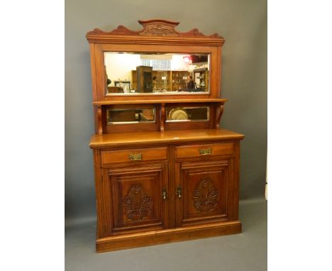 A late C19th walnut mirror backed sideboard with two drawers over two cupboards, with carved decoration and mirrored upper se