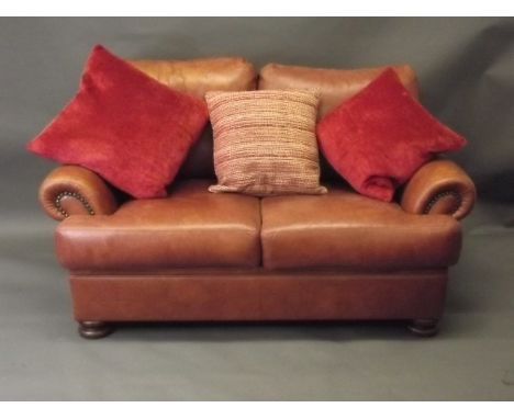 A John Lewis two seater sofa in tan leather, 57'' x 33'' x 35''