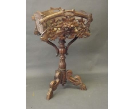A C19th Black Forest carved and pierced planter on a turned and carved column, on scrolled tripod legs ending in hairy paw fe