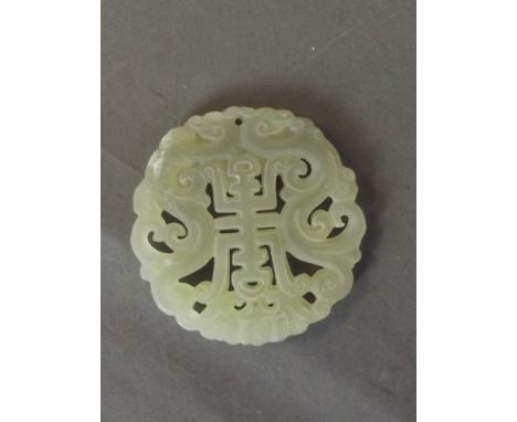 A Chinese pierced and carved circular jade pendant decorated with twin dragons and character inscription, 2'' diameter