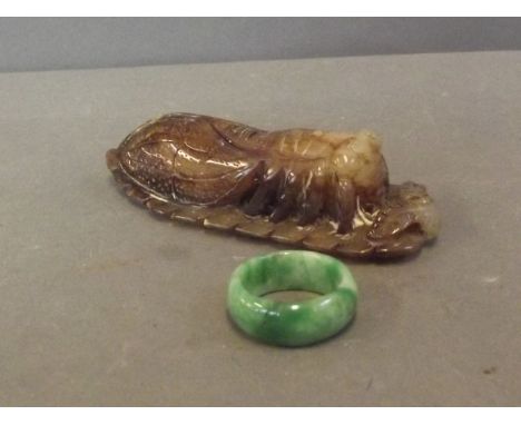 A C20th soapstone carved in the form of a cricket, and a bi-colour jade ring, 3½'' long
