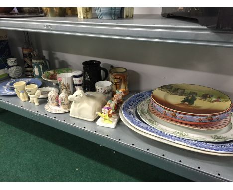 A shelf containing a large quantity of various china including meat plates.