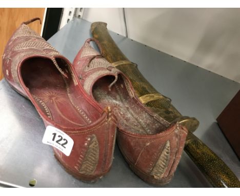 A pair of Eastern leather slippers together with an Eastern knife in shagreen effect scabbard with brass mounts.