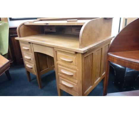 A large oak roll top desk with fitted interior, six drawers to front, resting on tapered supports.