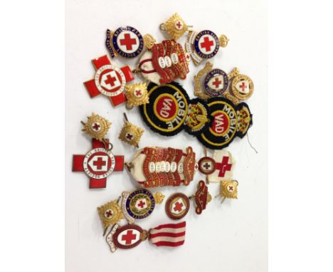 A small collection of early 20th century and other enamel British Red Cross Society badges together with two cloth badges.