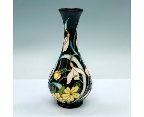 A small black glazed vase adorned with yellow primrose and white snowdrop flowers. Moorcroft and artist's markings on the bas