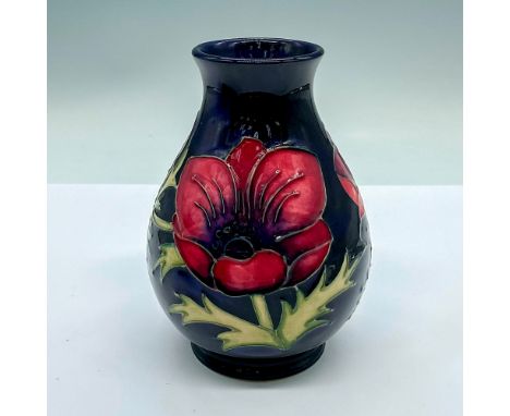 Small dark blue ground vase with purple and maroon flower. Moorcroft and artist's markings on the base. This item has its ori