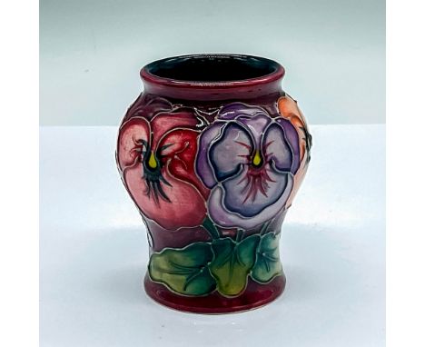 A small glazed vase with a maroon exterior and dark cyan interior. Decorated in a pink, purple, and orange pansy pattern. Moo