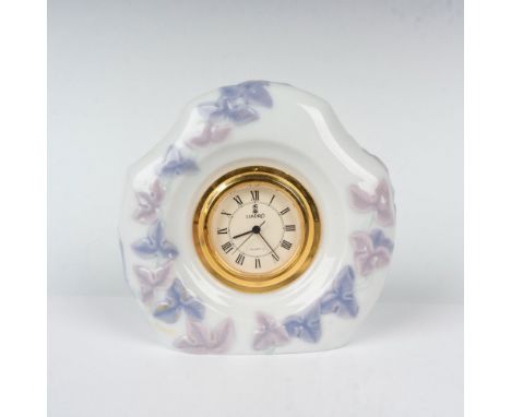 Glossy finish table clock featuring pink and purple raised flowers with gilded clock. Lladro backstamp. This item has its ori