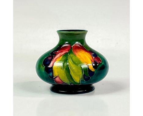 Stunning squat vase decorated with tube line berries and leaves on a green ground. W Moorcroft Made in England backstamp. Thi