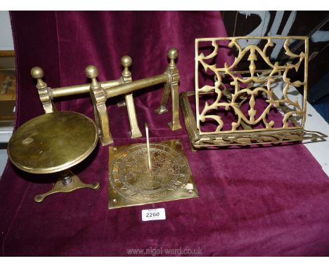 A small quantity of brass including a book stand, miniature table, sundial and pair of fire-dogs (a/f).