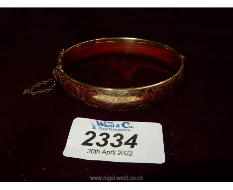 A rolled gold Bangle with safety chain, by L &amp; Co.