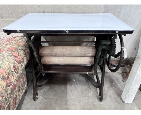 An early 20th century mangle with hinged enamel top, width 77cm, depth 46cm, height 75cm