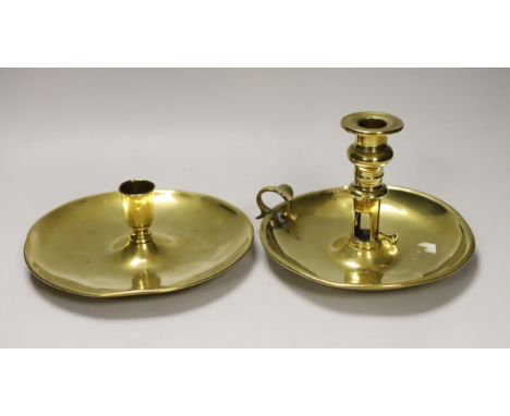An 18th / 19th century brass saucer candlestick and an 18th century brass chamber candlestick, on circular tray