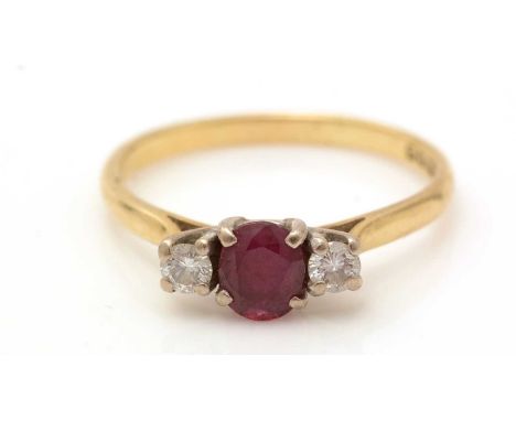 A ruby and diamond ring, the circular facet-cut ruby flanked by two brilliant cut diamonds weighing a total of approximately 