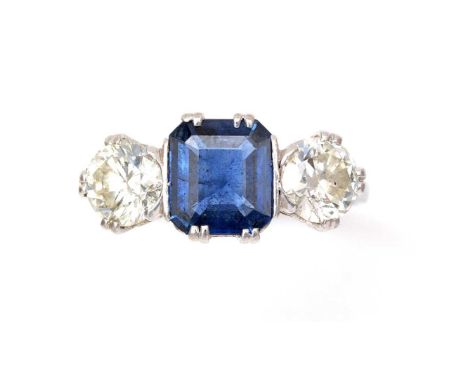 A sapphire and diamond ring, the canted-square step cut sapphire measuring 7.7 x 6.8 x 2.9mm, flanked by two brilliant cut di