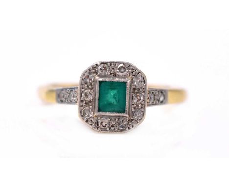 An emerald and diamond cluster ring, the rectangular step-cut emerald surrounded by eight-cut diamonds, in platinum mount and