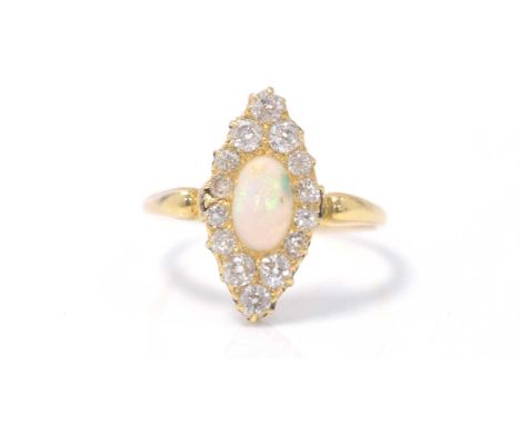 A Victorian opal and diamond ring, the oval opal cabochon set within fourteen old-cut diamonds, in 18ct yellow gold mount and