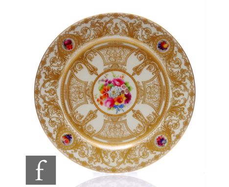 A Royal Worcester hand painted cabinet plate, decorated to the centre with a floral spray by E. Phillips, within a wide gilt 