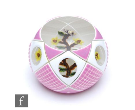 A William Manson double overlay glass paperweight, internally decorated with stylised flower on a branch, cased with pink and