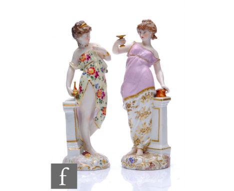 Two 19th Century Dresden type figurines, the first a lady stood draped in robes holding aloft a gilt goblet stood beside a pe