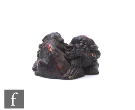A Japanese carved hardwood carving or netsuke, modelled as two carved shishi entwined, height 3cm. 