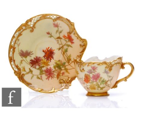 A Royal Worcester shape 1471 Empress blush ivory teacup and saucer decorated with sprays of flowers and foliage with pierced 