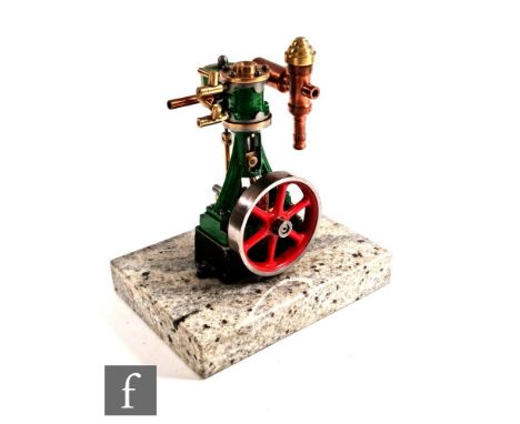 A scale model of a Stuart steam engine, single red painted fly wheel, vertical piston, mounted on a speckled marble plinth, h
