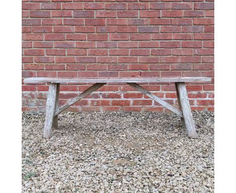 A rustic elm bench The bench with a plain rectangular top and trestle supports.151cm wide x 29cm deep x 49cm highQty: 1In wea