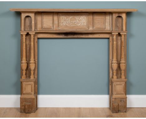 An Edwardian pine fire surround or chimneypiece With a carved tablet and outset, turned columns beneath niches.160cm wide x 2