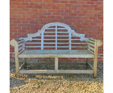 A Lutyens-style teak garden bench The camel-back and the seat with slats enclosed by scrolling arms.165cm x 105cmQty: 1Notabl
