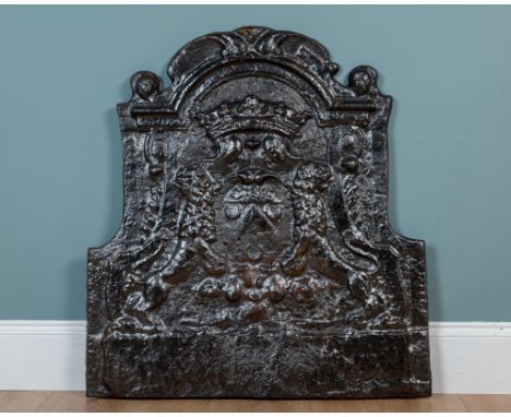 An antique French, possibly 17th century, cast iron fire back The arching fire back of shaped form, with a central Heraldic c