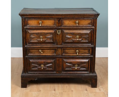 An 18th century oak chest of drawers The four long drawers with mitred panel decoration to the fronts raised on bracket feet.