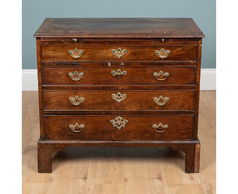 A George III small-sized chest of drawers The chest with a brushing slide over four long graduated drawers, beneath a crossba