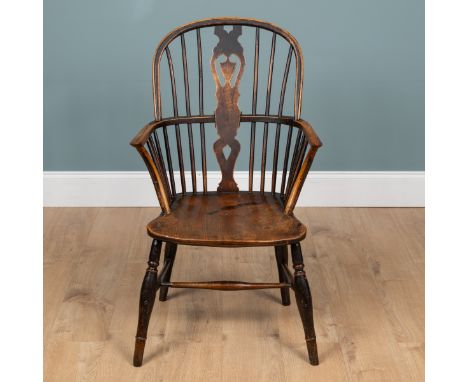 An ash and elm Windsor armchair The pierced splat with shield shaped ornament on a carved saddle seat and turned legs united 