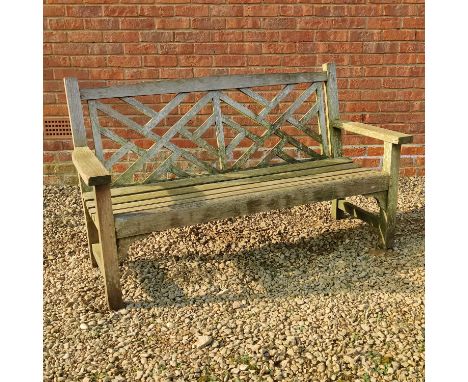 A teak garden bench With a latticework back.150cm wide x 65cm deep x 88cm highQty: 1In weathered good condition. Seemingly st