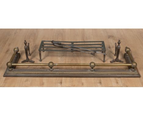 A group of fireside implements The lot to consist of a brass fender, a steel trivet and fire dogs, and a steel poker and matc