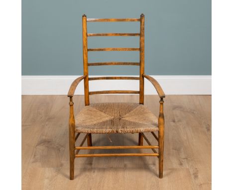 A 20th century Liberty nursing chair The ladder back above a rush seat raised on tapered legs united by stretchers.53cm x 87c