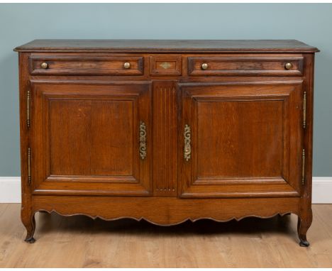 A 19th century French oak buffet With two frieze drawers either side of a central panel, panelled doors either side of a flut