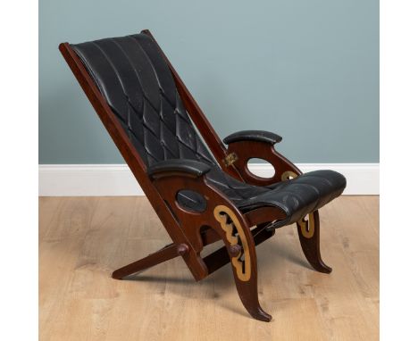 A 20th century mahogany-framed leather reclining campaign chair With a ratchet adjustable recliner and arms folding in on hin