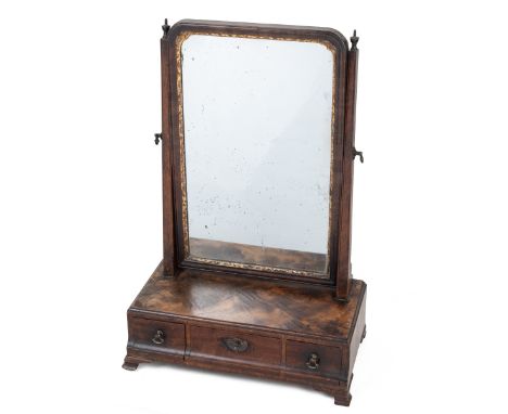A George III toilet mirror The swing mirror with a shaped frame and gilt slip, the plain support with turned urn finials, all