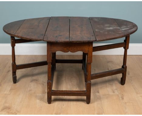 An18th/19th century oak gateleg table With a circular top and a fitted drawer to the frieze, raised on turned legs united by 