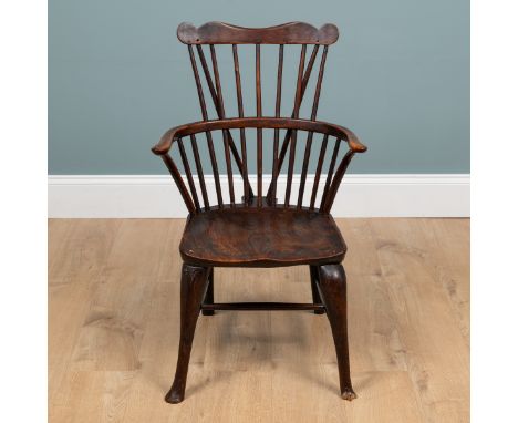 A 19th century comb-back Windsor armchair With an elm seat and gently cabrioled front legs, the legs united by an H-frame str
