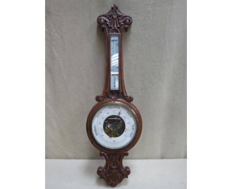 Victorian carved oak cased aneroid banjo barometer, with enamelled skeleton dial and mounted themometer. Approx. 83cms high 